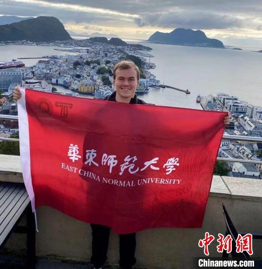 2021年华东师大迎来了70周年校庆,乌力在挪威的一艘船上挥舞着华东师大的旗帜。 华东师范大学供图 2021年华东师大迎来了70周年校庆,乌力在挪威的一艘船上挥舞着华东师大的旗帜。 华东师范大学供图